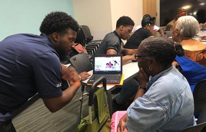Adrian helping senior learn how best to use mobile devices